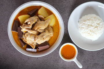 chicken curry or kari ayam made from coconut milk, spices, potato and chicken blood . usually eaten with cooked rice or vermicelli rice