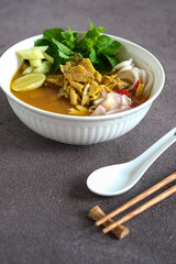 asam laksa, laksa medan is rice noodle, fish with sour soup and a little sweet and spicy. topping cucumber, onion, chili and mint leaves