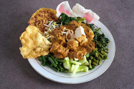 pecal or Indonesian salad is a boiled vegetables topping with tofu, tempeh, peanut sauce and crackers
