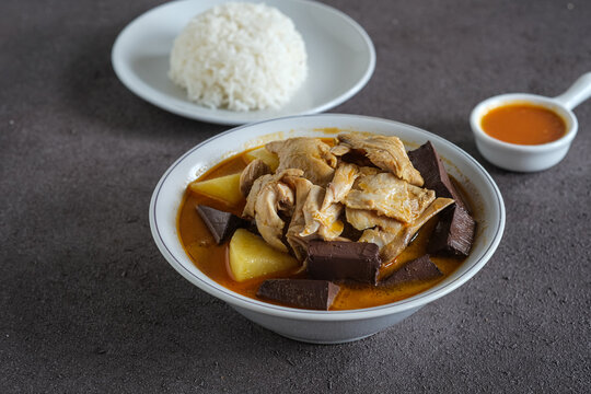 chicken curry or kari ayam made from coconut milk, spices, potato and chicken blood . usually eaten with cooked rice or vermicelli rice