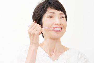 歯磨きをする中年女性　白背景