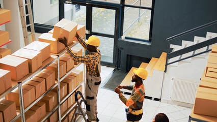 Group of workers working on stock inventory in depot, organizing packages and boxes on racks and...