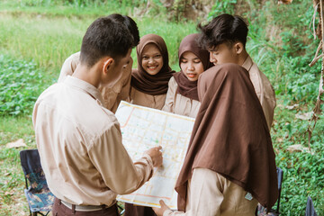 male scouts hold and point to a location map during a joint briefing