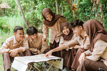 boy scout pointing finger at map during briefing together with squad leader