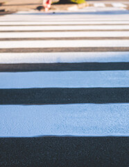 Process of making new road surface markings with a line striping machine, workers improve city infrastructure, demarcation marking of pedestrian crossing with a hot melted paint on asphalt pavement