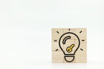 light bulb and key icons on wooden cubes with white background.Key to success concept.Learning and...