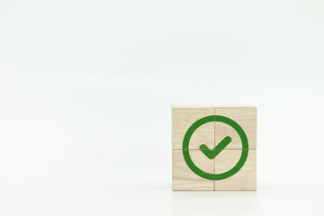 Wooden cube with green checkmark icon. Corporate regulatory and compliance. Goals achievement and business success. Task completion. Ethical corporate. Do the right thing. Quality and ISO symbol. 