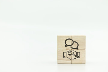 Handshake and communication icons on wooden block cubes on white background.Negotiating business, agreement, collaboration, merger and acquisition, business concept.