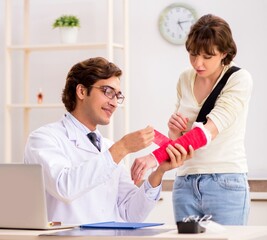 Fototapeta premium Young woman visiting doctor traumatologist