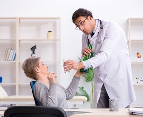Obraz premium Female alcoholic visiting young male doctor