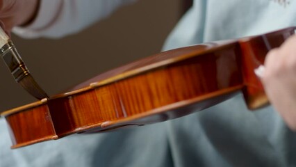 artisan luthier varnishing and final brush strokes to a handmade classic violin 4k video
