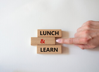 Lunch and learn symbol. Concept words Lunch and learn on wooden blocks. Beautiful white background. Businessman hand. Business and Lunch and learn concept. Copy space