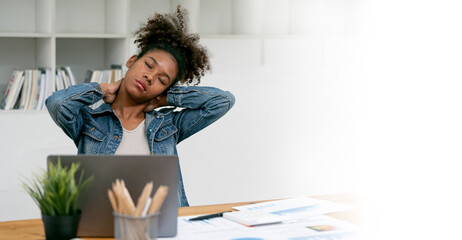 African Businesswoman with Neck Pain Using Laptop working at office.