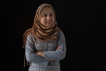 Muslim woman or Pakistani woman in traditional costume standing and arms folded, smiling and...
