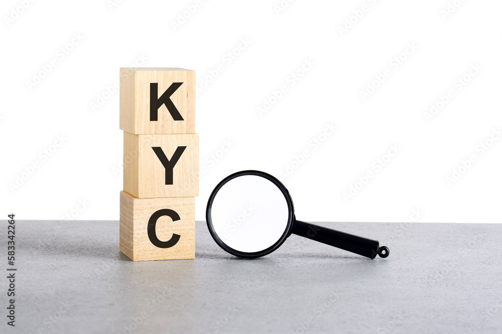 Poster kyc - know your client - text wooden cube blocks and magnifying glass on grey table