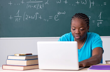 Black female student in front of chalkboard