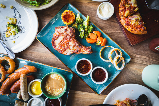 Well done grilled pork chop steak in  plate and vegetable salad