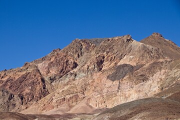 Fototapeta na wymiar Driving along Artist's Drive, a one-way scenic loop in Death Valley, reveals rocks with a surprising number of colors. It is home to Artist's Pallette, which has a dusting of green and pink colors.
