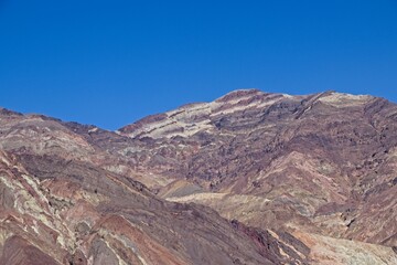 Driving along Artist's Drive, a one-way scenic loop in Death Valley, reveals rocks with a...