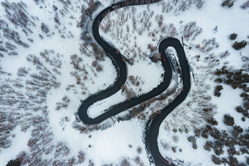 Driving on winter roads trough forest winding road in the mountains
