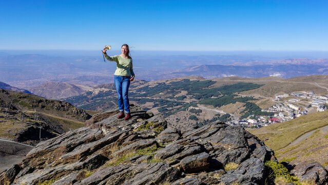 Young Caucasian woman dressed in jeans and sweatshirt enjoying the views of the Alpujarra valleys of Granada