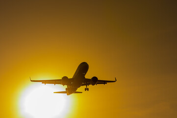 Bottom view of a flying plane at sunset. 