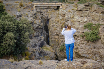 Young Caucasian woman dressed in jeans and sweatshirt enjoying the views of the Alpujarra valleys of Granada