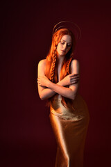 Close up fantasy portrait of beautiful woman model with red hair, goddess silk robes & gold crown. ...
