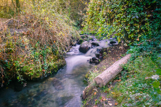 slow speed image of a stream with a small waterfall where the water looks like silk