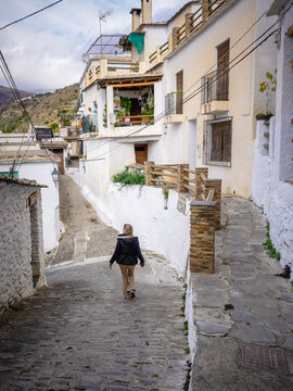 Young and blonde woman walking through the streets of a town in the Alpujarra of Granada