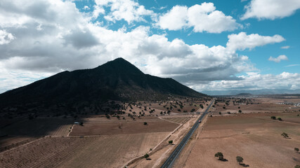 Highway next to an arid mountain and desert in Mexico.