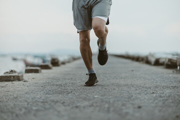 healthy lifestyle young fitness man running at seaside old bridge. Outdoor workout,  Healthy...