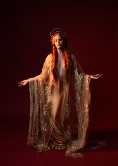 Full length fantasy portrait of beautiful woman model with red hair, goddess silk robes & gold...