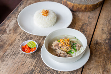 Delicious Pork Rib Soup or Soto Iga Babi Served with Chili Sauce or Sambal and Steam Rice