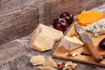 Different type of cheese and nuts on vintage wooden background in studio photo