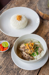 Delicious Pork Rib Soup or Soto Iga Babi Served with Chili Sauce or Sambal and Steam Rice
