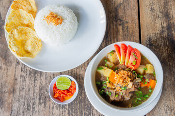Delicious Oxtail Soup or Soup Buntut Served with Chili Sauce or Sambal and Steam Rice