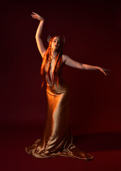 Full length fantasy portrait of beautiful woman model with red hair, goddess silk robes & gold...