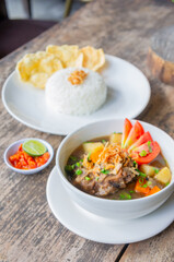 Delicious Oxtail Soup or Soup Buntut Served with Chili Sauce or Sambal and Steam Rice