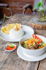 Delicious Oxtail Soup or Soup Buntut Served with Chili Sauce or Sambal and Steam Rice