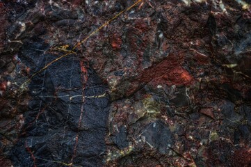 Dark background stone heterogeneous texture. volcanic rock interspersed with minerals.