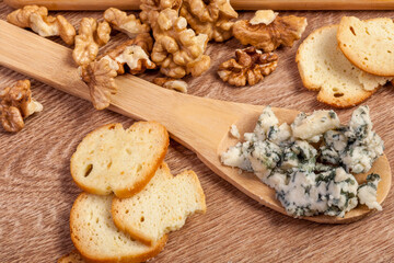 Nuts, crackers and cheese. Healthy food. Differet type of cheese on wooden background.