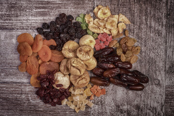 Different type of raw dried fruits on wooden type background in rich HDR toning.