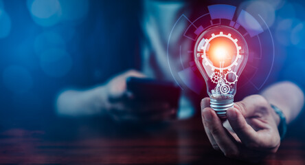 Businessman holding light bulb with gear icon like business Innovation ideas and financial vision