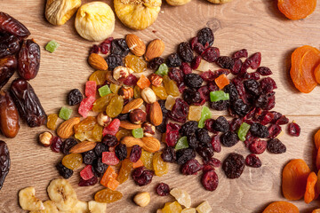 Dried fruits and nuts on wooden background. Healthy food. Fresh raw nuts and fruits