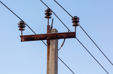 Electric wire on a pole against the blue sky