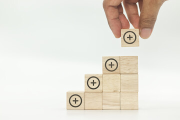 Plus sign icons on wooden block cubes shape stairs on white backgroud.Positive things concept,...