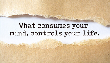 What consumes your mind, controls your life. Words written under torn paper. Motivation concept text.