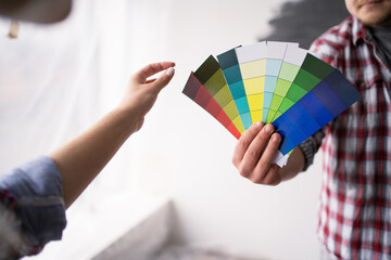 Couple looking at color samples at home. Repair home, interior design and renovation concept
