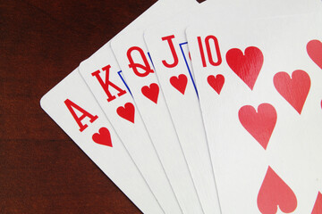 Close up of hearts playing cards on wooden table. 